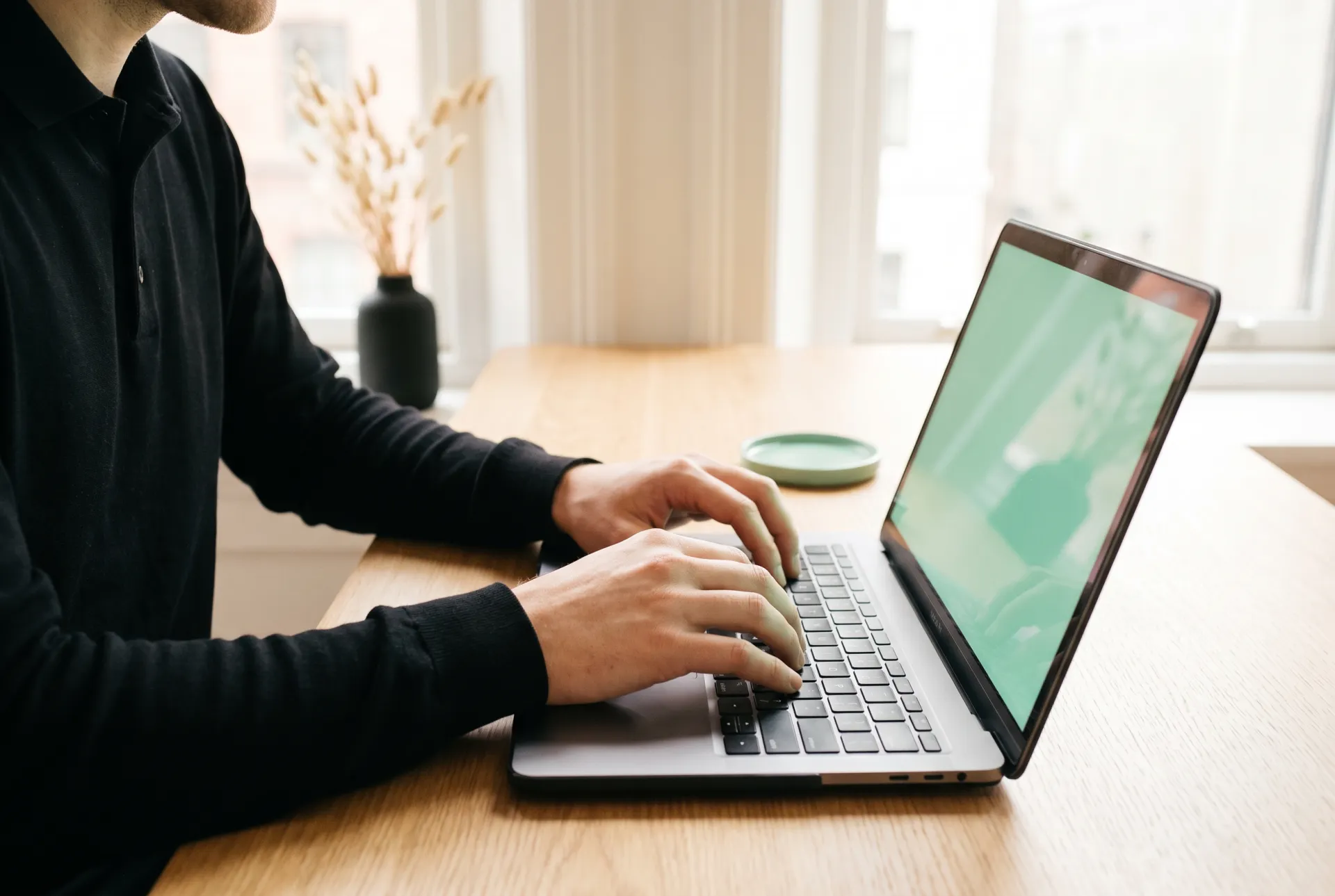 Hände tippen eine Frage an die Wissens-Basis in die Tastatur