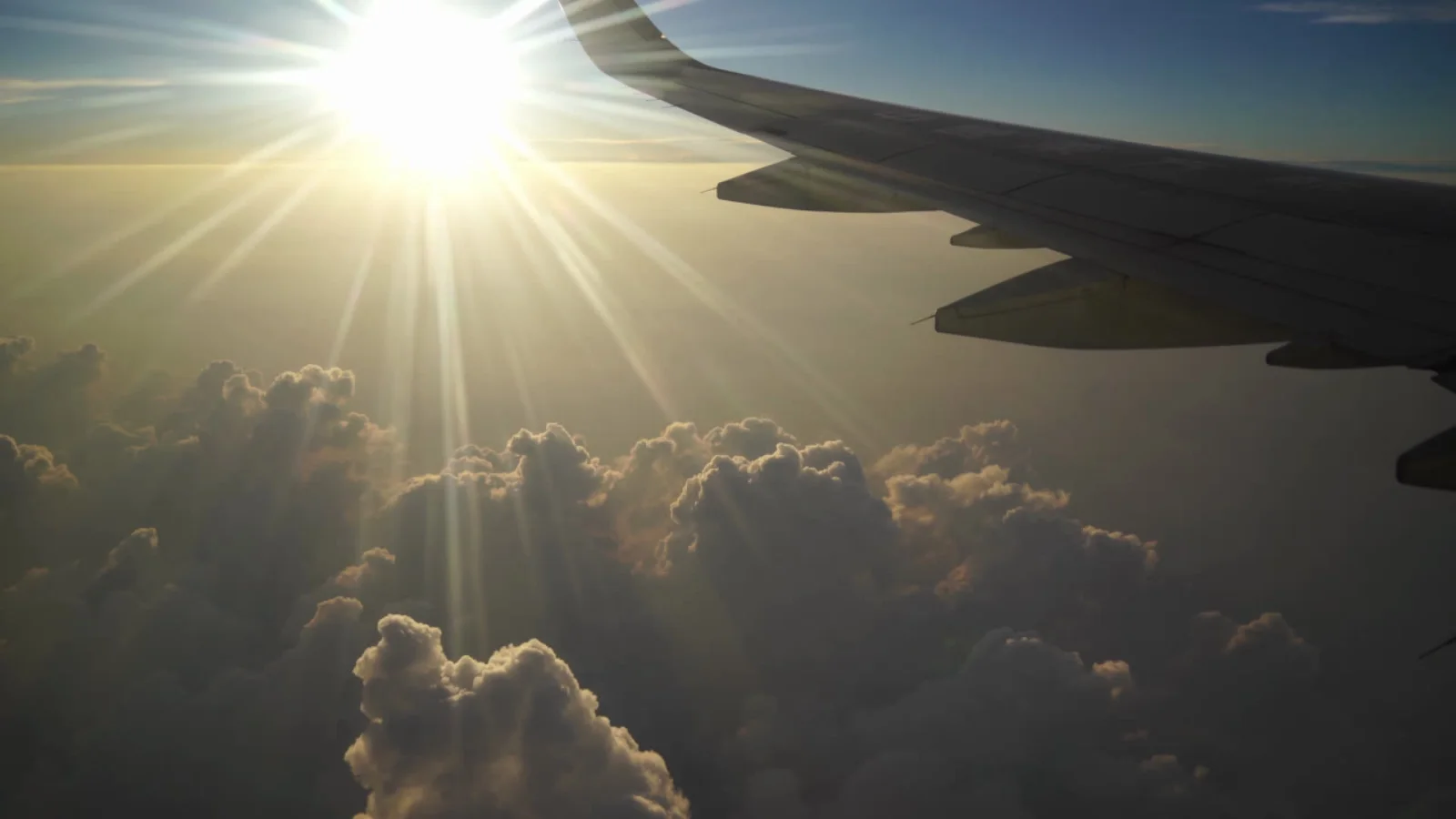 Blick aus dem Flugzeug auf die Tragfläche über goldenen Wolken, Reference Case Discover Airlines.